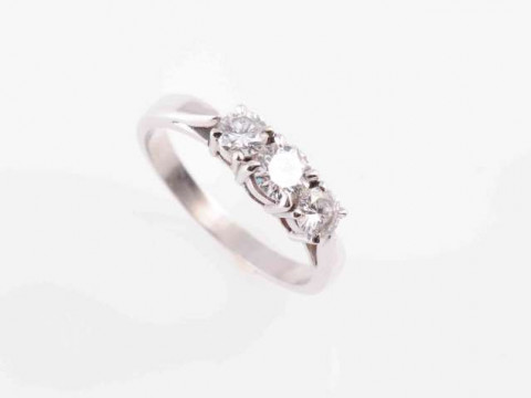 A THREE STONE DIAMOND RING, the slightly graduating three brilliant-cut...