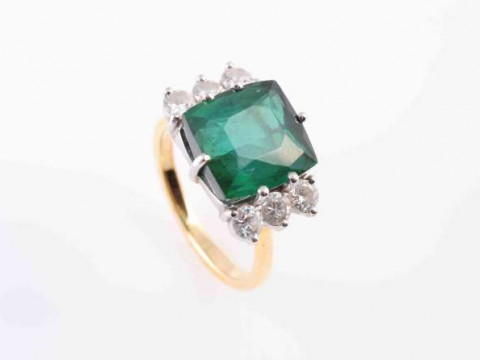 A TOURMALINE AND DIAMOND RING, the square cushion cut green tourmaline...