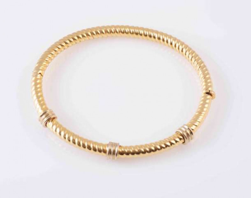 A YELLOW GOLD COLOURED BANGLE, the rope work design bangle with three moulded spacers to the upper section. Clasp marked '750'. Inner diameter approximately 6.8cm. Total weight approximately 17.5gms.