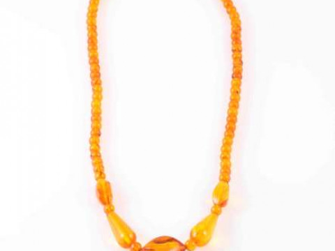 AN AMBER COLOURED BEAD NECKLACE, the seventy six beads of differing shapes...