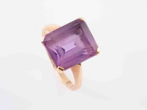 AN AMETHYST RING, the square cut amethyst four claw set in an open pierced...