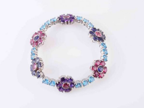 AN AMETHYST, TOURMALINE AND TOPAZ BRACELET, the six flower heads set with...