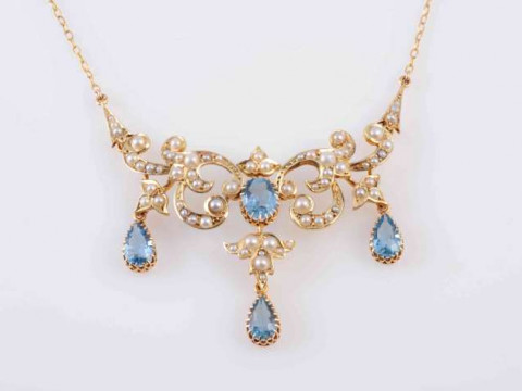 AN AQUAMARINE AND SEED PEARL NECKLACE, CIRCA 1900, the three pear cut...