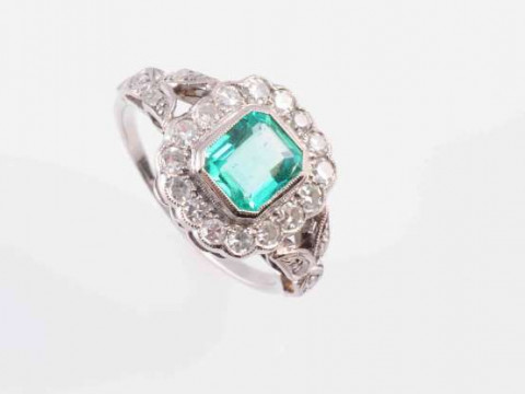 AN EMERALD AND DIAMOND RING, CIRCA 1910, the square cut emerald collet...