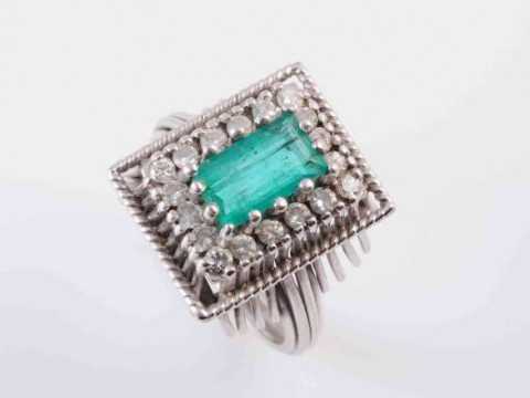 AN EMERALD AND DIAMOND RING, the rectangular cut emerald fourteen claw...