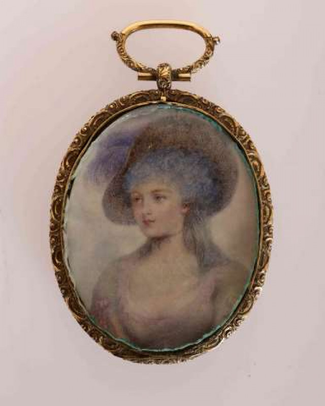 A PORTRAIT MINIATURE, of a lady, on ivory, oval, in a yellow metal frame with engine-turned back. Overall 9cm by 6cm