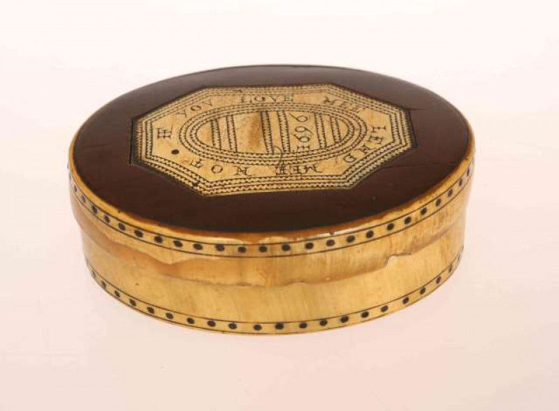 A WILLIAM III FRUITWOOD AND HORN SNUFF BOX, oval, the fruitwood inset cover with horn plaque engraved IF YOU LOVE ME LEND ME NOT and dated 1696, the base and cover with dotted border. 8.5cm by 6.5cm