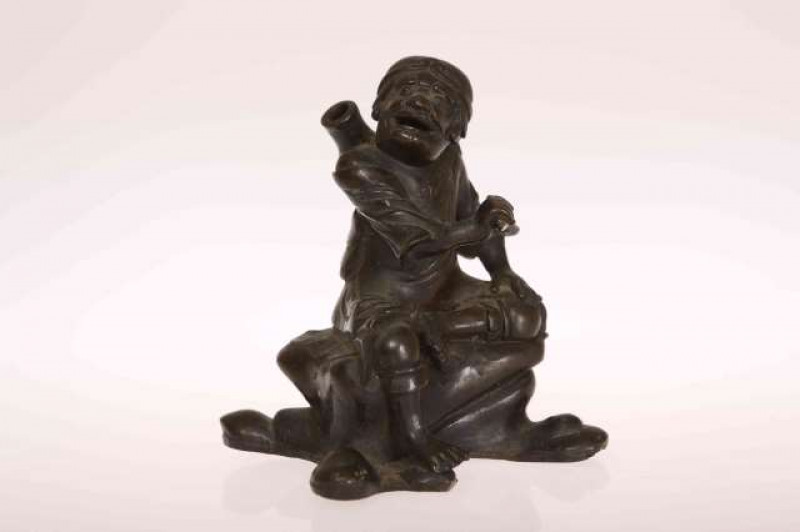 A CHINESE BRONZE FIGURE, cast as a seated man, probably 19th Century. 11cm