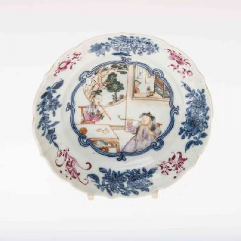 A CHINESE EXPORT SAUCER DISH, 18TH CENTURY, the centre painted with figures in an interior, one seated smoking, another playing a flute, a child watches in the background. 14.5cm