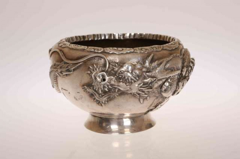 A CHINESE EXPORT SILVER BOWL, late 19th Century, double walled, embossed in high relief with a three-clawed dragon, character marks to base. 17.1oz, 11cm by 18cm