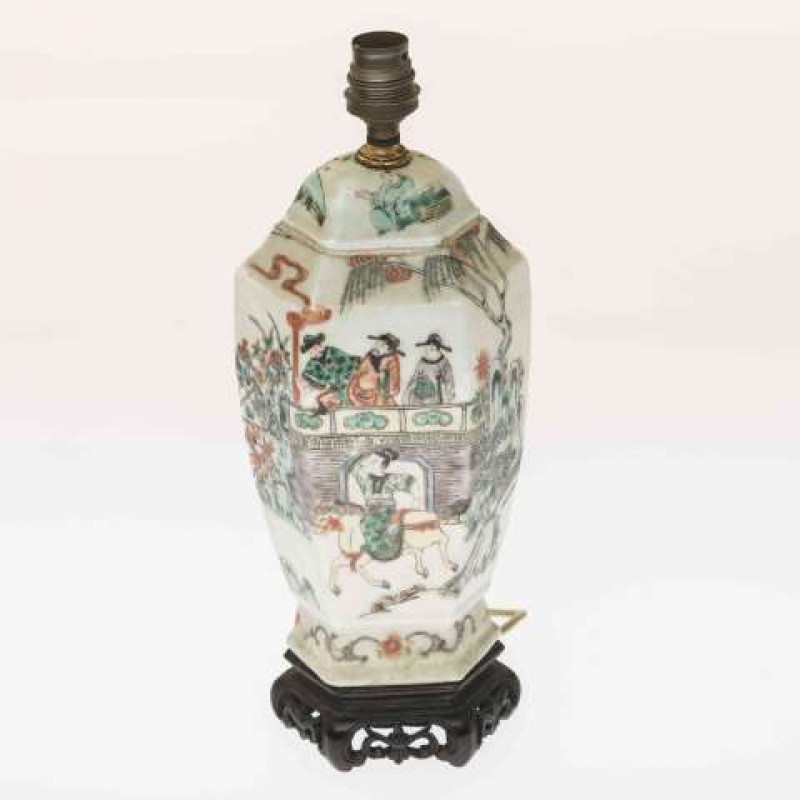 A CHINESE FAMILLE VERTE KANGXI STYLE VASE, 19TH CENTURY, of hexagonal section, painted with figures standing and mounted, rocks and foliage, on a wooden stand, adapted for electricity. Overall 33cm