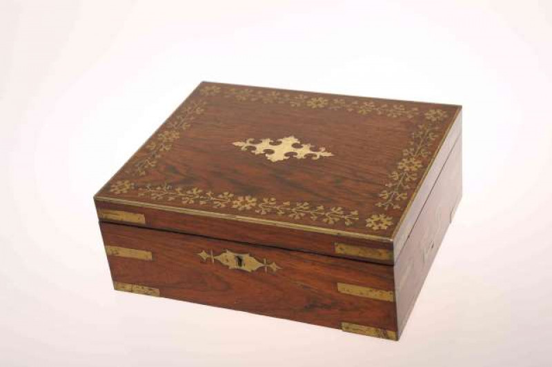A 19TH CENTURY BRASS AND ROSEWOOD CAMPAIGN BOX, with brass bound corners and cut-out brass inlay, the interior with lift-out trays and compartments. 12cm by 30cm by 24.5cm