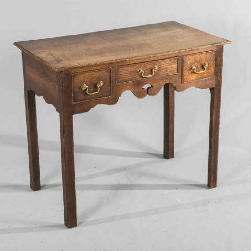 A GEORGE III OAK LOWBOY, the rectangular moulded top above three frieze drawers with bail handles, raised on chamfered square section legs. 72cm by 84cm by 47cm