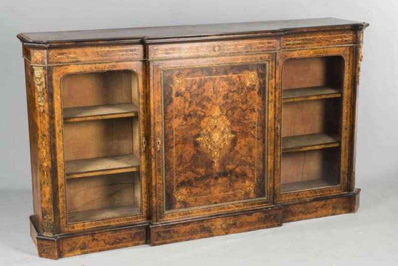 A BURR WALNUT AND GILT METAL MOUNTED CREDENZA, CIRCA 1860, the moulded breakfront top above an inlaid frieze over a cupboard door flanked by a pair of glazed doors. 104cm by 182cm by 42cm