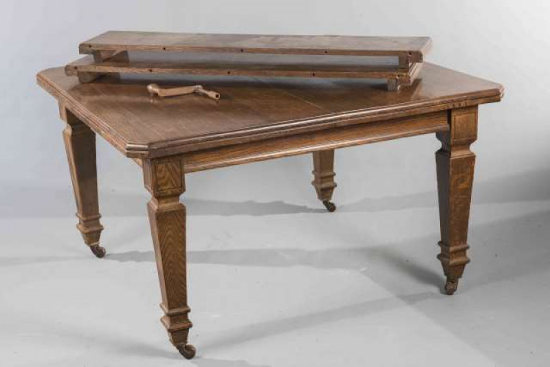 A LATE VICTORIAN OAK DINING TABLE, with canted corners and square section legs, moving on castors. 73cm by 127cm by 120cm