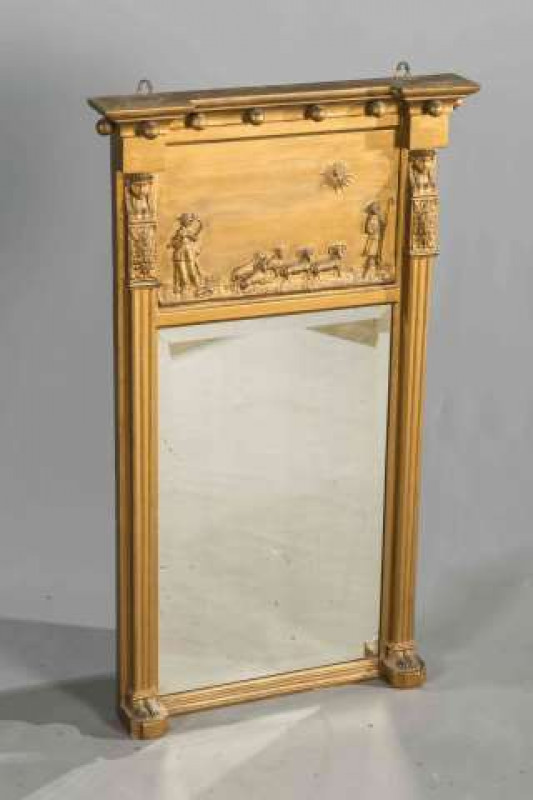 A REGENCY EGYPTIAN REVIVAL GILT COMPOSITION PIER MIRROR, moulded with the busts of pharaohs and shepherds to the frieze. 100cm by 59cm