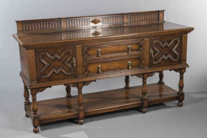 A WARING AND GILLOWS OAK SIDEBOARD, CIRCA 1920, the moulded front with a pair of cupboard doors flanking a pair of drawers, raised on block and baluster legs joined by a shelf stretcher. 105cm by 182cm by 58cm