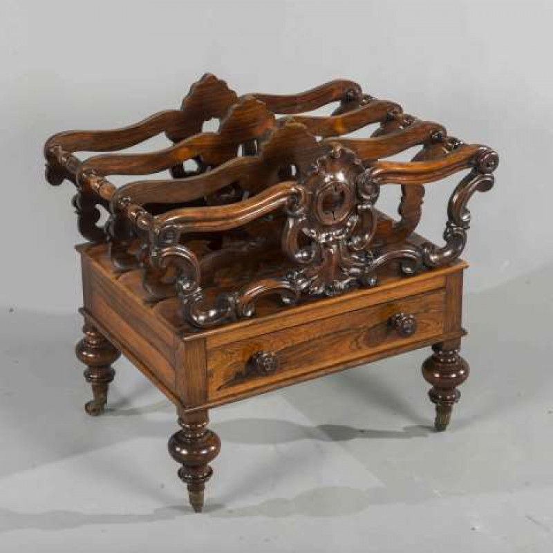 A WILLIAM IV ROSEWOOD CANTERBURY, with shell and scroll carving, the base with a drawer, moving on brass castors. 55cm wide