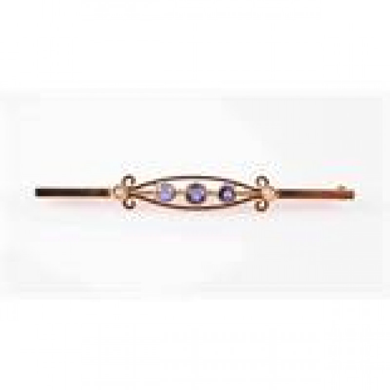 A SAPPHIRE AND SEED PEARL BROOCH, the open moulded scroll detail mount set to the centre with three graduating round mixed cut collet set sapphires, between two collet set seed pearl highlights, on a flat edge bar with brooch pin fitting. Stamped 15CT. We