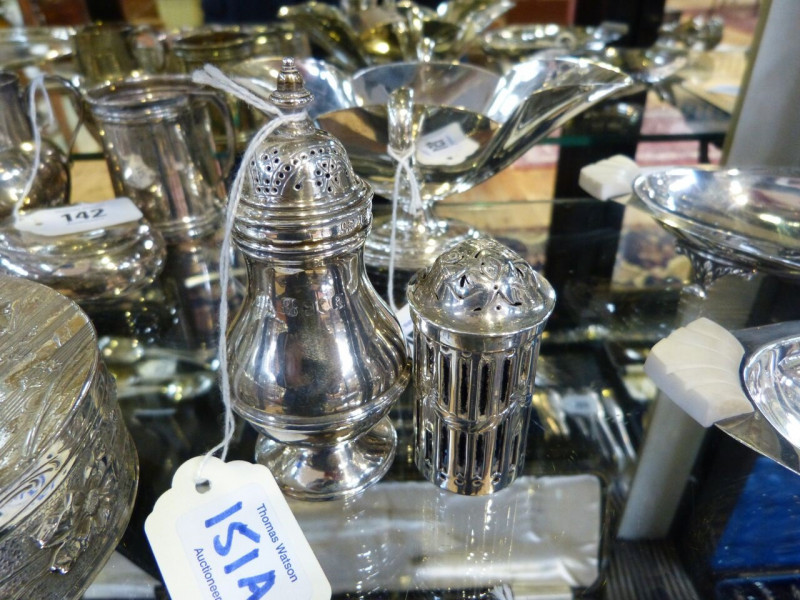 A LATE VICTORIAN SILVER BALUSTER PEPPER CASTER, Charles Stuart Harris, London 1896, 10.5cm; together with A GEORGE III SILVER PEPPER POT, London 1801, cylindrical with bun top and pierced sides enclosing a blue glass liner, 6.5cm. (2)