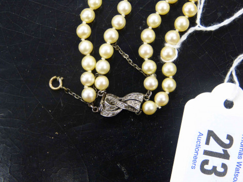 A CULTURED PEARL NECKLACE, the one hundred and fifty graduating cultured pearls all strung knotted into two graduating rows, onto a bow design integral tongue clasp set throughout with eight graduating diamond highlights, and safety chain. Total length ap thumbnail