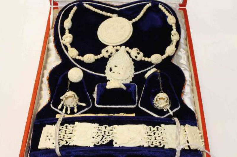 A suite of carved ivory jewellery, circa 1960's, comprising eight pieces: necklace with pendant, brooch, pair of chandelier earrings, ring, pair of clip earrings and bracelet; all carved with foliate motifs and animals, in a fitted box (bracelet 19cm long