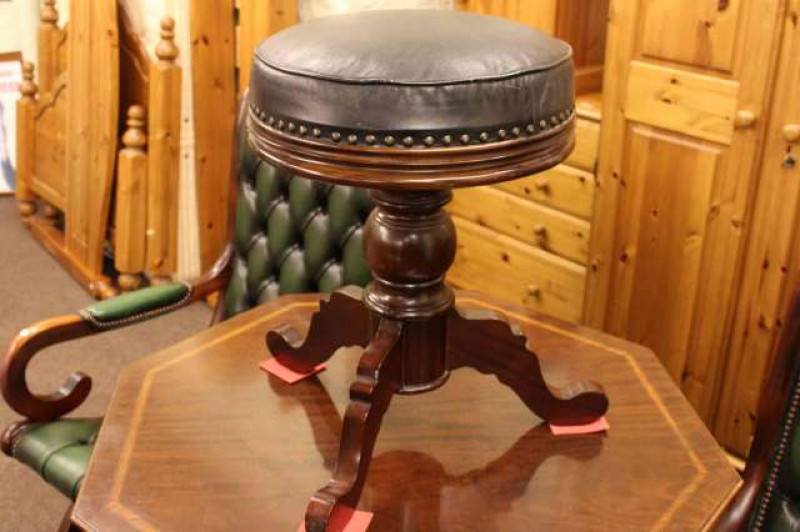 Modern mahogany leather seated revolving piano stool raised on turned pedestal base