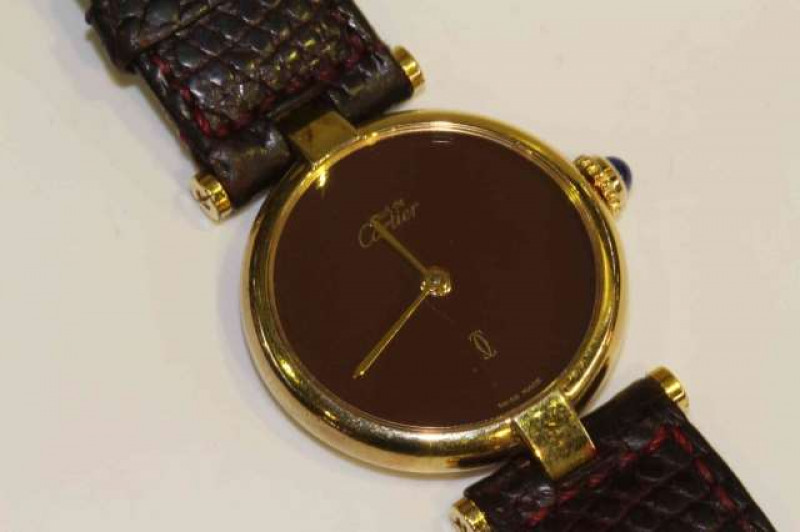 Must De Cartier, a lady's silver gilt wristwatch, quartz movement, circular red dial, numbered 18012910 to the case verso, cabochon set winding crown, with Cartier pouch. Diameter of case 25mm