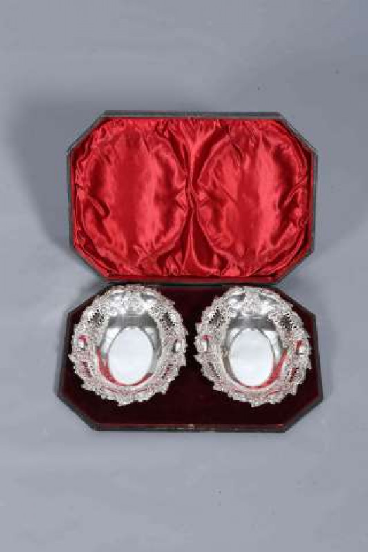 A CASED PAIR OF EDWARDIAN SILVER DISHES, Charles Harrold & Co, Birmingham 1902, oval, each pierced and embossed with foliage. Gross 13.8oz, 24.5cm by 18cm