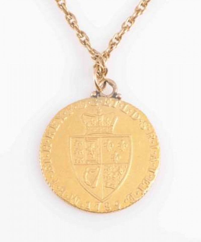 A GEORGE III GOLD SPADE GUINEA, 1789, now with suspension loop and 9 carat gold chain. Gross 14.8 grams