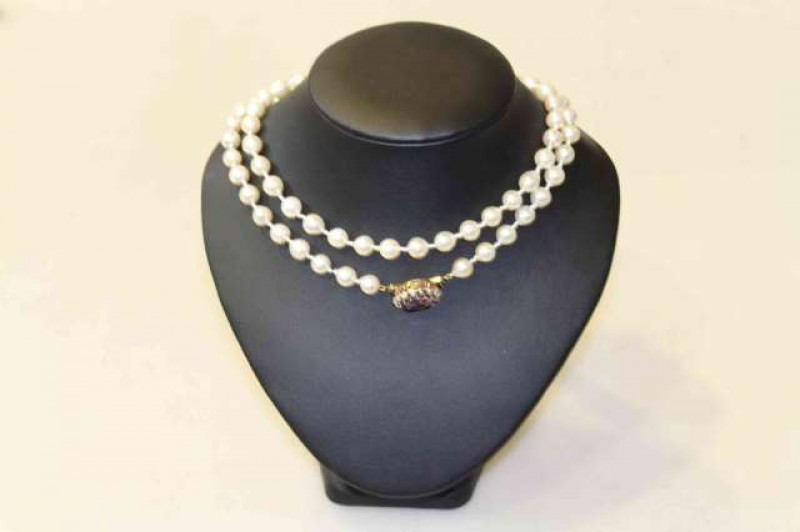 Single strand of long length baroque cultured pearls, on a 14 carat gold and amethyst clasp