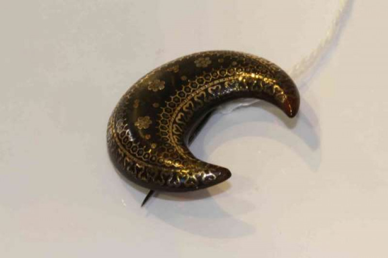A 19th Century tortoiseshell and gold pique brooch, the crescent shaped brooch set with delicate scroll and floral detailed gold pique work, on brooch pin fitting, diameter 3.5cm, weight 5.2gms