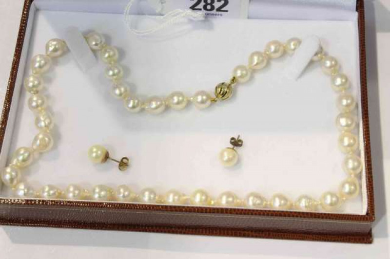 Baroque cultured pearl uniform single row necklace on a yellow gold clasp; with earrings en-suite