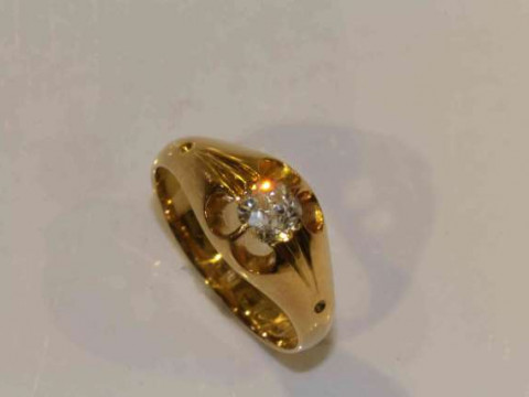 A diamond ring, the cushion cut diamond eight claw set to the centre of...