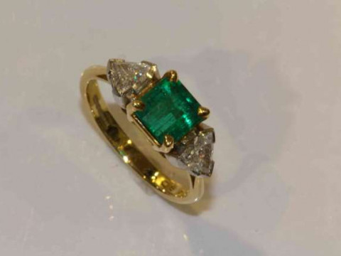 An emerald and diamond ring, the square cut emerald four claw set between...