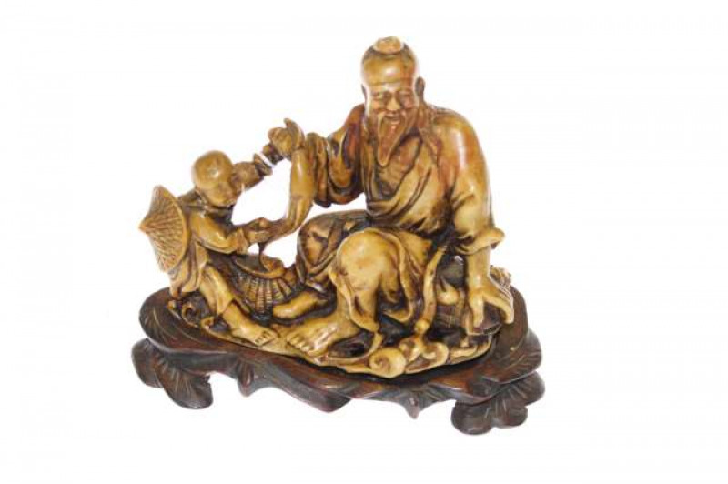 Oriental soapstone carving of fisherman and child on wood stand