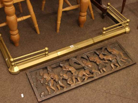 Brass extending fender and carved ethnic wall plaque