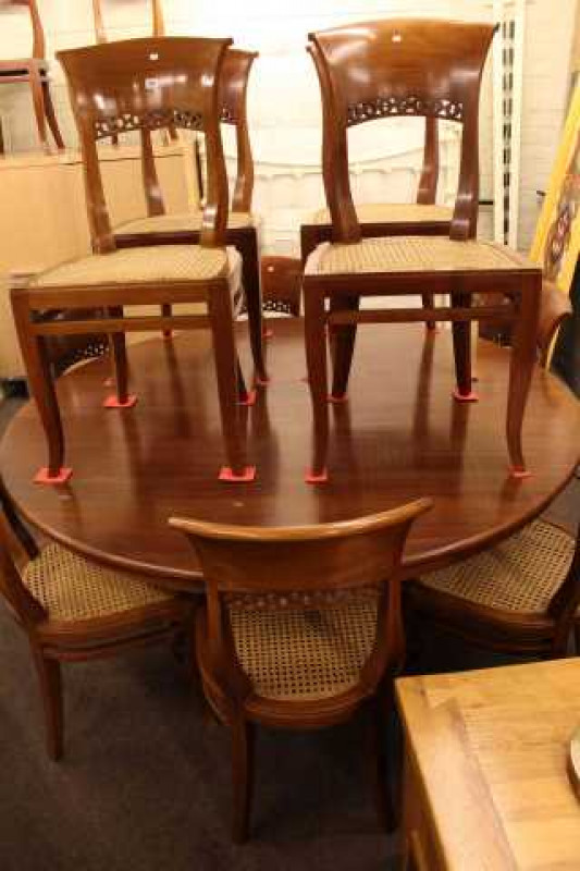 Large circular dining table on pedestal quadriform base and twelve bergere seated dining chairs