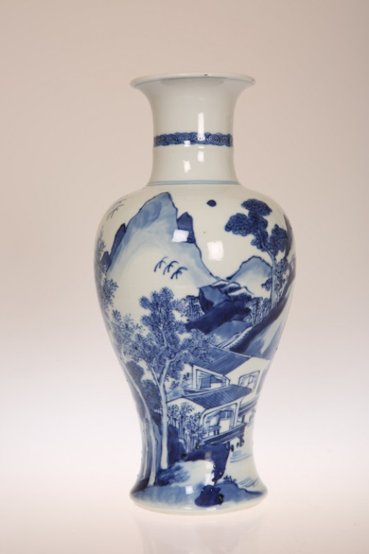 A CHINESE BLUE AND WHITE BALUSTER VASE, painted in the round with figures in a mountainous landscape, artemisia leaf mark within double circles. 27cm