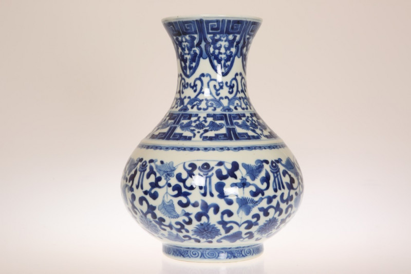 A CHINESE BLUE AND WHITE PORCELAIN VASE, of baluster form, painted with a band of Greek Key to the flared rim above bands of foliate scrollwork, with six character mark. 25cm