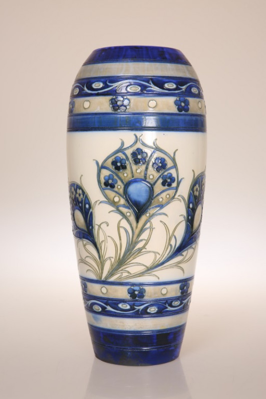 WILLIAM MOORCROFT (1872-1945) A 1930'S SALT GLAZED VASE, of ovoid form, tubelined and hand painted with peacock feathers, blue painted signature and impressed marks. 31.5cm