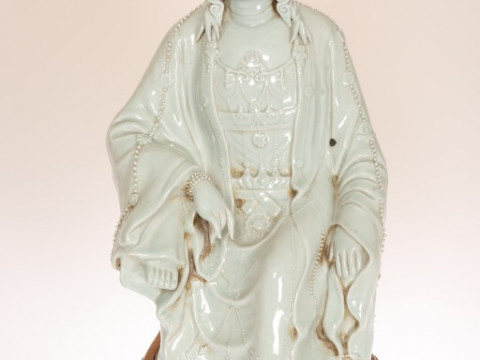 A LARGE CHINESE CELADON GLAZED POTTERY FIGURE OF QUAN YIN, modelled seated...