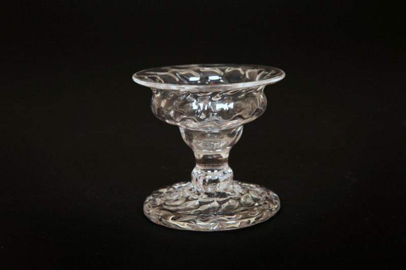 A SMALL GLASS PATCH STAND, CIRCA 1770, the moulded bowl with flared rim, on a baluster stem and moulded circular foot. 5.5cm by 5.75cm