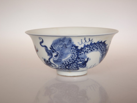 A SMALL CHINESE BOWL, the exterior painted with a five-clawed dragon chasing...