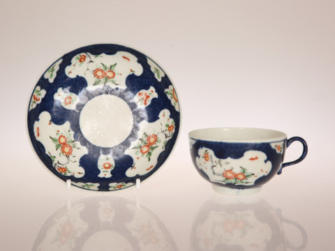 A WORCESTER SCALE BLUE GROUND CUP AND SAUCER, CIRCA 1770, enamelled in...