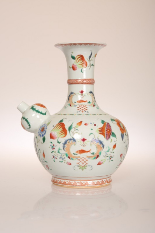 A CHINESE PORCELAIN KENDI OR WINE PITCHER, enamel painted in the famille rose palette with crests and flowers. 24cm