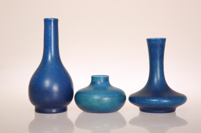 A GROUP OF THREE PILKINGTONS ROYAL LANCASTRIAN MATT BLUE LUSTRE VASES, the first of slender baluster form, the second of squat baluster form with elongated neck, the third of squat baluster form and lighter blue mottled glaze, each with impressed marks. (