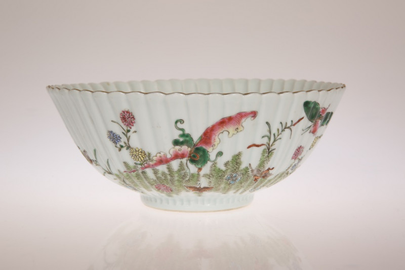A CHINESE FAMILLE ROSE FLUTED BOWL, decorated with butterflies and fish amongst foliage, four character mark to base. 21cm diameter