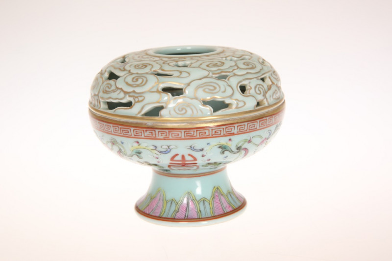 A CHINESE FAMILLE ROSE PORCELAIN CENSER AND COVER, with celadon ground, the domed cover moulded and pierced with clouds, the body with shou characters and flowers beneath a band of Greek Key, on circular foot painted with leaves, four character blue ename