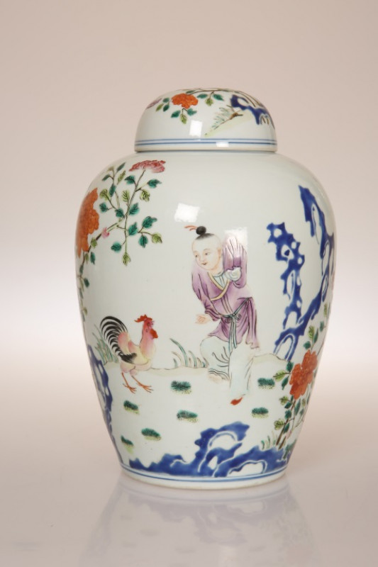 A CHINESE FAMILLE ROSE 'CHICKEN' VASE AND COVER, painted with a figure in a garden watching a cockerel, hen and six chicks beneath a poem. 23cm